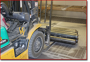loading roller cans into grit blast chamber